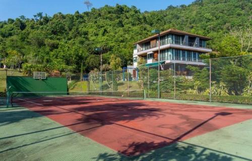 a tennis court with a house in the background at The Height Khaoyai Resort in Ban Huai Sok Noi