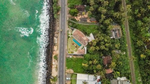 an aerial view of a house next to the ocean at Marshmallow Bay Boutique Hotel & Surf Point Adults Only in Ahangama