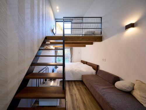 a room with a bed and a couch and a staircase at TrollForestStella in Nikko