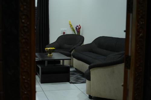 a living room with two chairs and a table at Mango Resort Washi Hills in Kolhapur