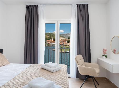 a bedroom with a bed and a chair and a window at Villa SENKA in Rogotin