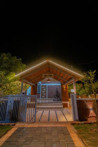 a house with a lit up front porch at night at Mango Resort Washi Hills in Kolhapur