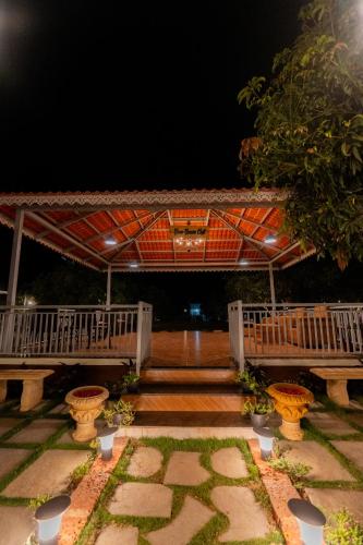 a deck with benches and stairs at night at Mango Resort Washi Hills in Kolhapur