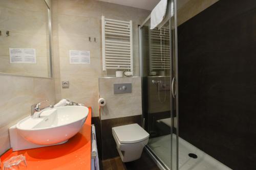 a bathroom with a sink and a toilet and a shower at Pension Kursaal in Donostia-San Sebastián