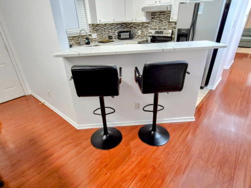 a kitchen with two bar stools in front of a counter at Arlington Social in Arlington