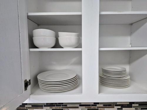 a white cabinet with plates and bowls in it at Arlington Social in Arlington