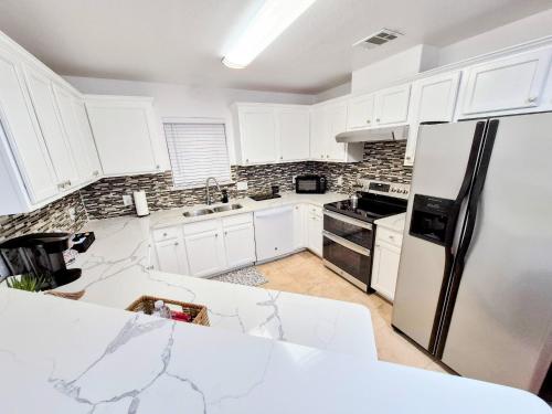 a kitchen with white cabinets and a black refrigerator at Arlington Social in Arlington