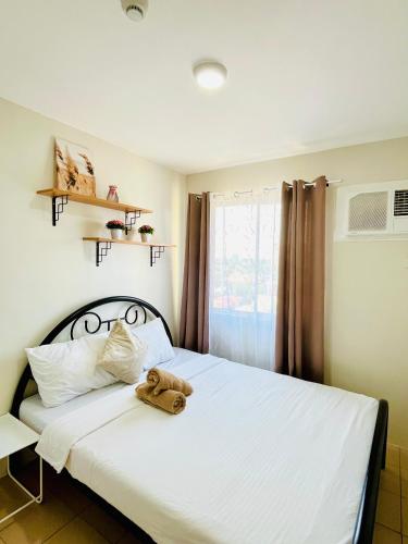 a teddy bear sitting on top of a bed at 2 Bedrooms Budget Friendly Condotel in Iloilo City in Iloilo City