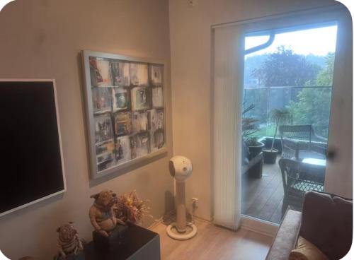 a living room with a television and a sliding glass door at Moderne Leilighet in Stord