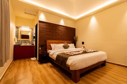 a bedroom with a large bed with two pillows on it at Mango Resort Washi Hills in Kolhapur