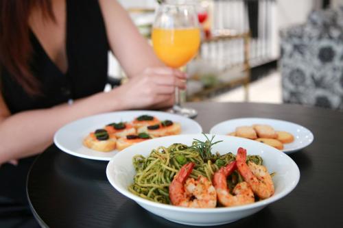 een vrouw aan een tafel met twee borden eten bij CityHouse- El Pino Realm at Metro Ben Thanh Market in Ho Chi Minh-stad
