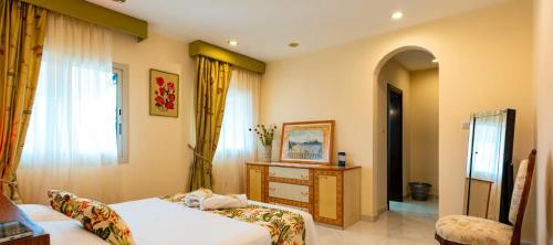 a bedroom with a bed and a dresser and a window at Ocean Pearl Villa in Anse Royale