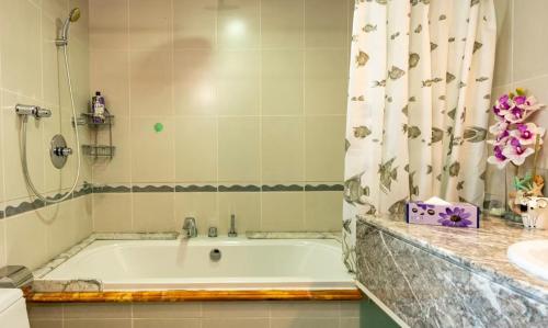 a bathroom with a bath tub and a sink at Ocean Pearl Villa in Anse Royale