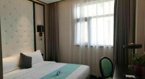 a hotel room with a bed and a window at Xana Hotelle·Tianshui Shangyi Plaza in Tianshui