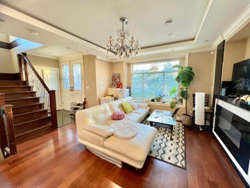 a living room with a white couch and a chandelier at Cozy stay in Cental Vancouver in Vancouver