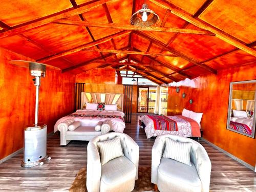 a bedroom with two beds and two chairs at Uros Qhantany Lodge in Puno
