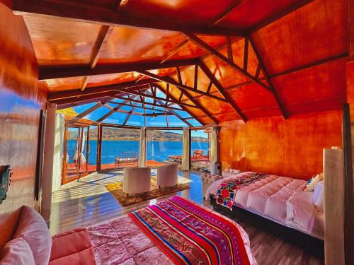 a room with two beds and a view of the ocean at Uros Qhantany Lodge in Puno