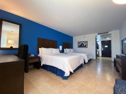 a hotel room with two beds and a flat screen tv at Holiday Inn Express Mérida by IHG in Mérida