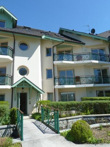 an apartment building with a gate in front of it at la baie des voiles ,vue lac d'Annecy ,plage privée in Duingt