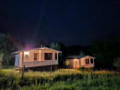 a house with lights on in a field at night at Căsuțele bucuriei in Pucioasa
