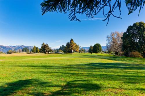 a view of a golf course with a green field at Mountain View - Kaikoura Holiday Home in Kaikoura