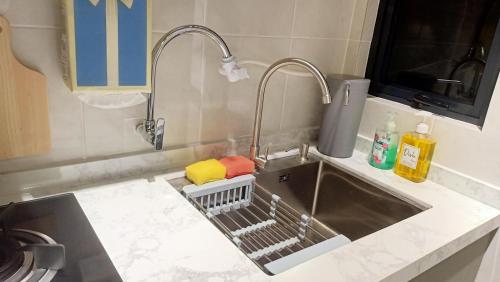 eine Küchenspüle mit zwei Wasserhähnen und einem Geschirrständer in der Unterkunft Nara Nook Homestay Bangi in Kajang