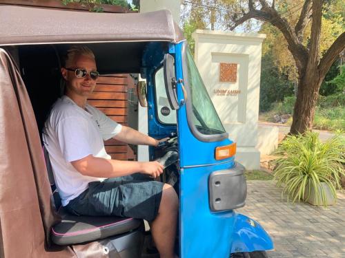 a man sitting in the back of a van at Livin Lush Luxury Retreat in Anuradhapura