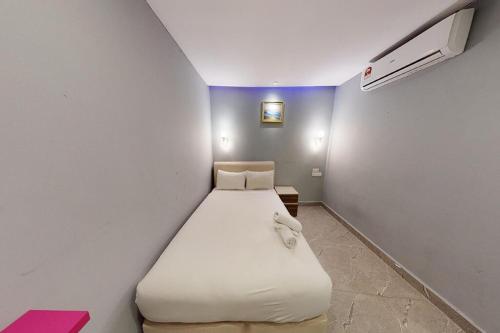 a small bedroom with a white bed in a room at Hotel Dlima Inn Bukit Bintang in Kuala Lumpur