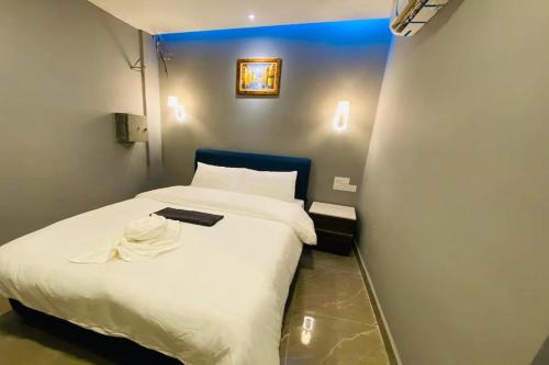 a small bedroom with a white bed in a room at Hotel Dlima Inn Bukit Bintang in Kuala Lumpur