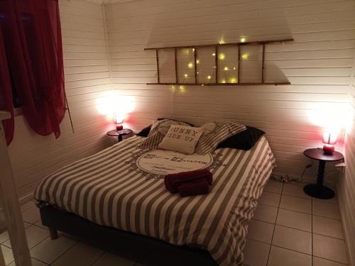 a bedroom with a bed with two lamps on it at Chez RAM'S in Le Tampon