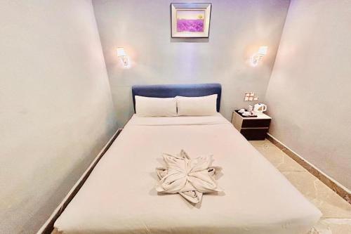 a bedroom with a bed with a flower on it at Hotel Dlima Inn Bukit Bintang in Kuala Lumpur