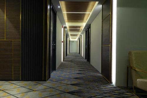 a corridor of a building with a long hallway at Holatel Hotel Phitsanulok in Phitsanulok