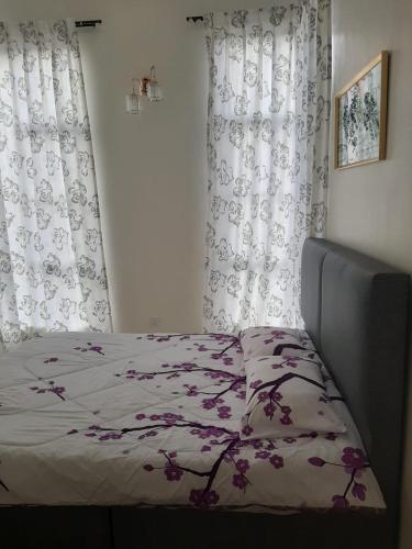 a bedroom with a bed with a flower patterned blanket at MK Homestay Sunway in Ipoh