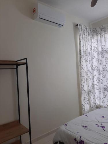 a bedroom with a bed and a window with a curtain at MK Homestay Sunway in Ipoh