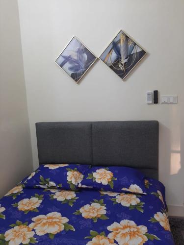 a bed with a blue comforter with two mirrors on it at MK Homestay Sunway in Ipoh