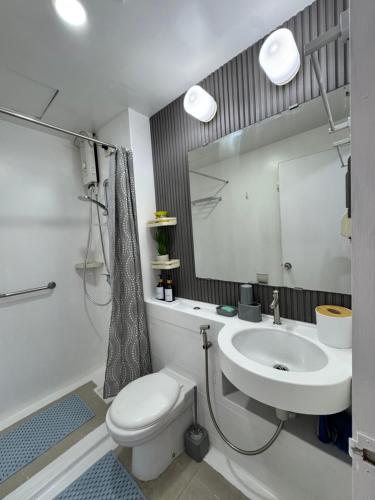 a bathroom with a sink and a toilet and a mirror at Condo in Malate in Manila
