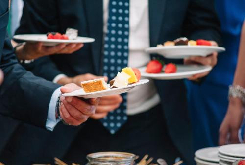 a group of people holding plates of desserts at Garner Hotel Augsburg Nord by IHG in Augsburg