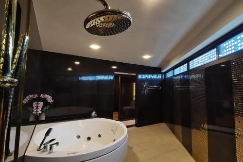 a large bathroom with a tub and a shower at Holatel Hotel Phitsanulok in Phitsanulok