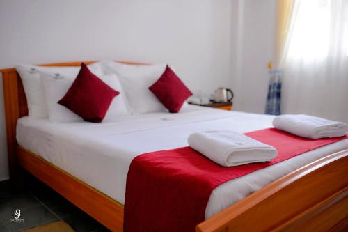 a bedroom with a bed with red and white pillows at Livin Lush Luxury Retreat in Anuradhapura