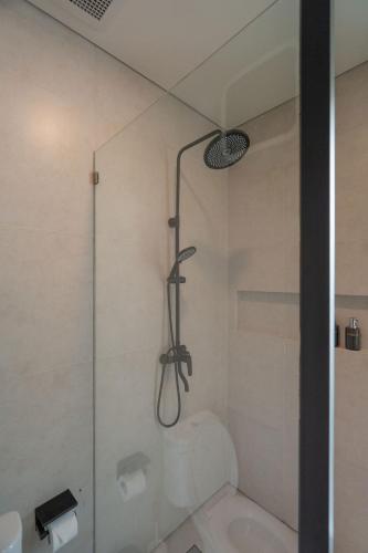 a shower in a bathroom with a glass door at Tuspa Ubud Villa in Ubud
