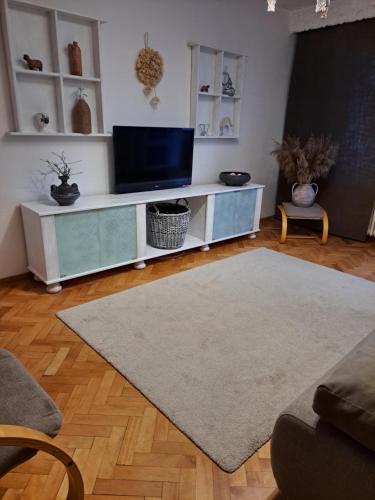 una sala de estar con TV en un centro de entretenimiento blanco en Boho Chic Apartament, en Reghin