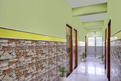 a hallway of a building with a stone wall at Hotel O Singh Guest House in Kolkata