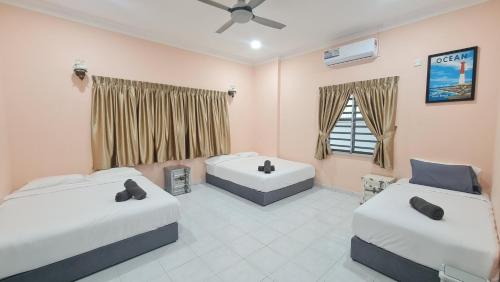 Un dormitorio con dos camas y una ventana. en NEW!!! AURORA HIDEAWAY VILLA 35pax 7R7B PRIVATE POOL, KTV, BBQ, ARCADE GAMES, 5min to BEACH, en Port Dickson