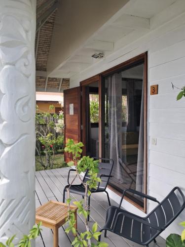 a porch with two chairs and a table at Moorea Island Beach Hotel in Moorea