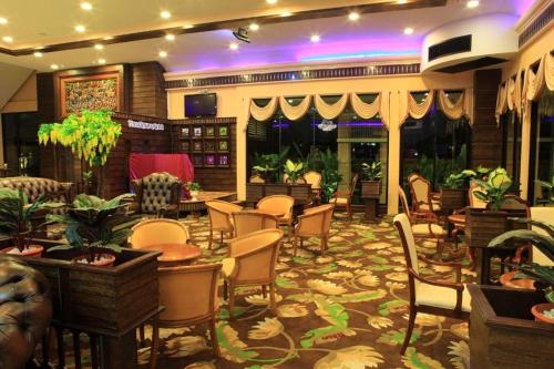 a hotel lobby with chairs and tables at Ruean Phae Royal Park Hotel in Phitsanulok