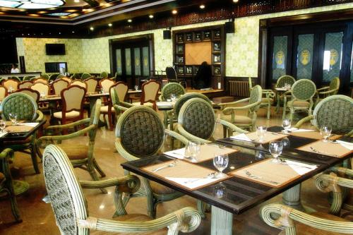 a restaurant with tables and chairs in a room at Ruean Phae Royal Park Hotel in Phitsanulok