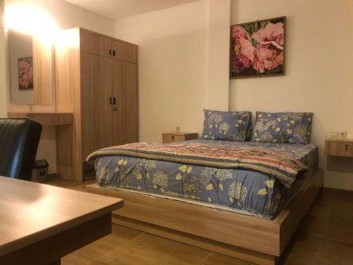 a bedroom with a bed with a table and a cabinet at Dwell Guesthouse Dago in Ciburial