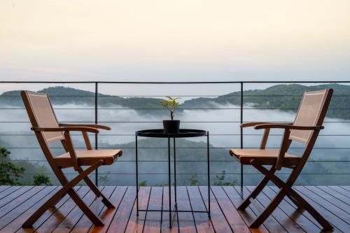 two chairs and a table on a balcony with a view at Glenross Living - A Collection of 7 Private Pool Villas and 3 Colonial Suites in Kalutara