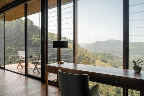 a home office with a desk and a view of the mountains at Glenross Living - A Collection of 7 Private Pool Villas and 3 Colonial Suites in Kalutara
