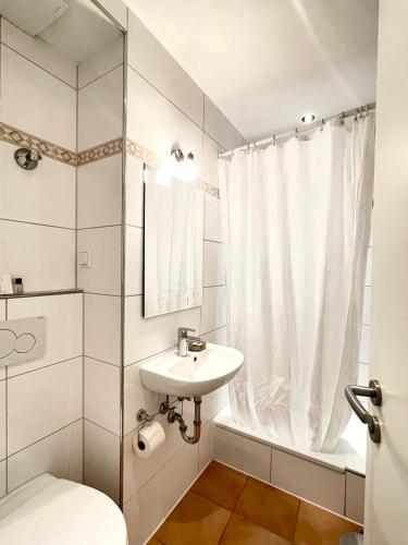 a bathroom with a sink and a toilet and a shower at Barcelona Bed & Breakfast in Düsseldorf